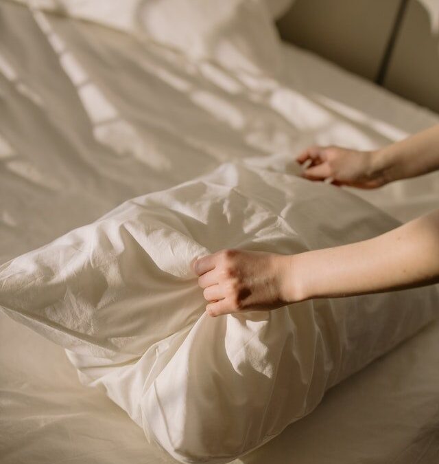 Mani femminili su un cuscino poggiato sul letto